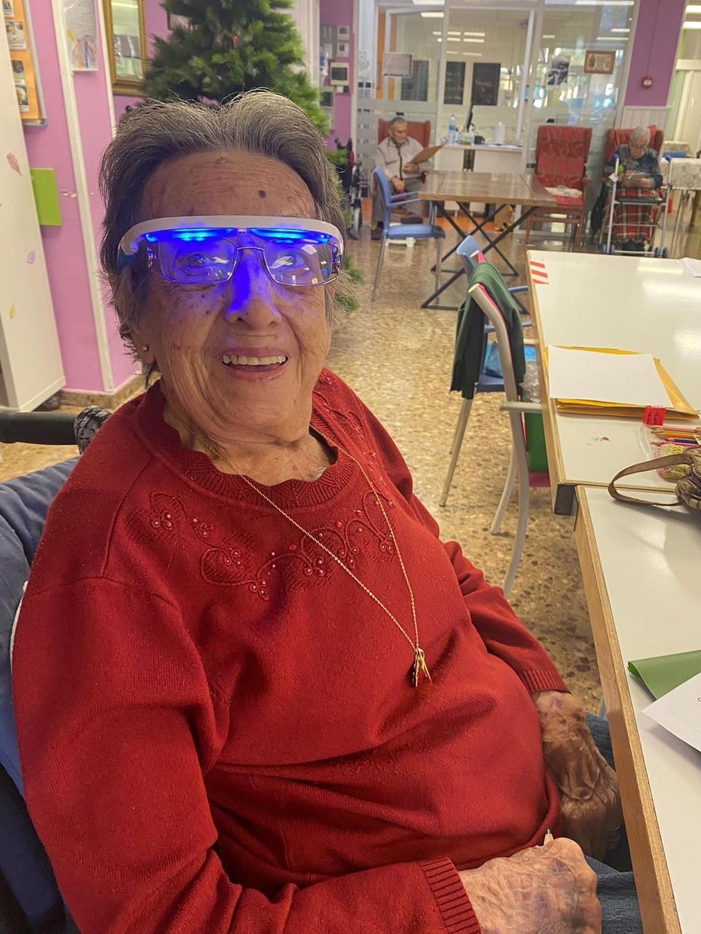 An elderly person seated wearing AYO light glasses.
