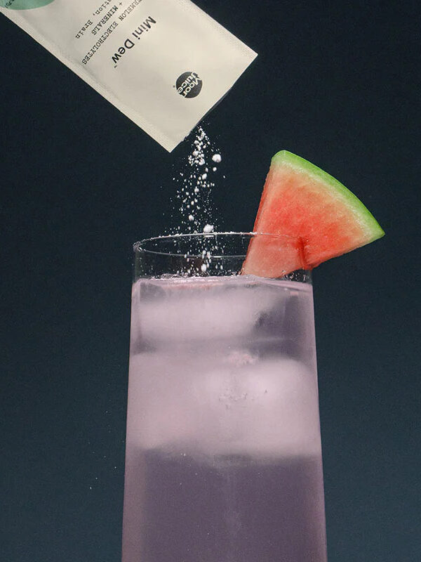 A sachet of Moon Juice's Mini Dew being poured into a glass.