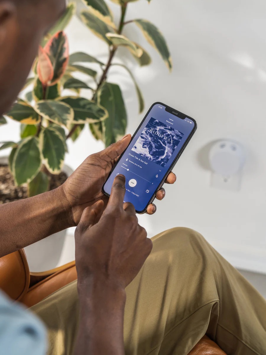 A model adjusting their Pura device via the Pura app on their phone.