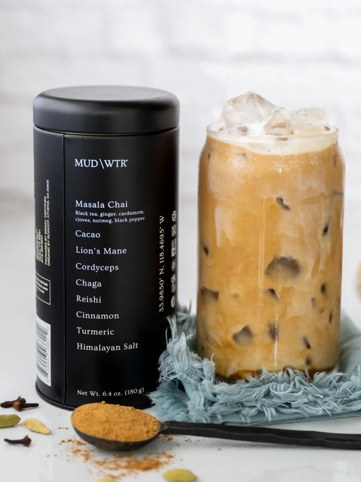 A tin of MUDWTR next to an iced MUDWTR latte.