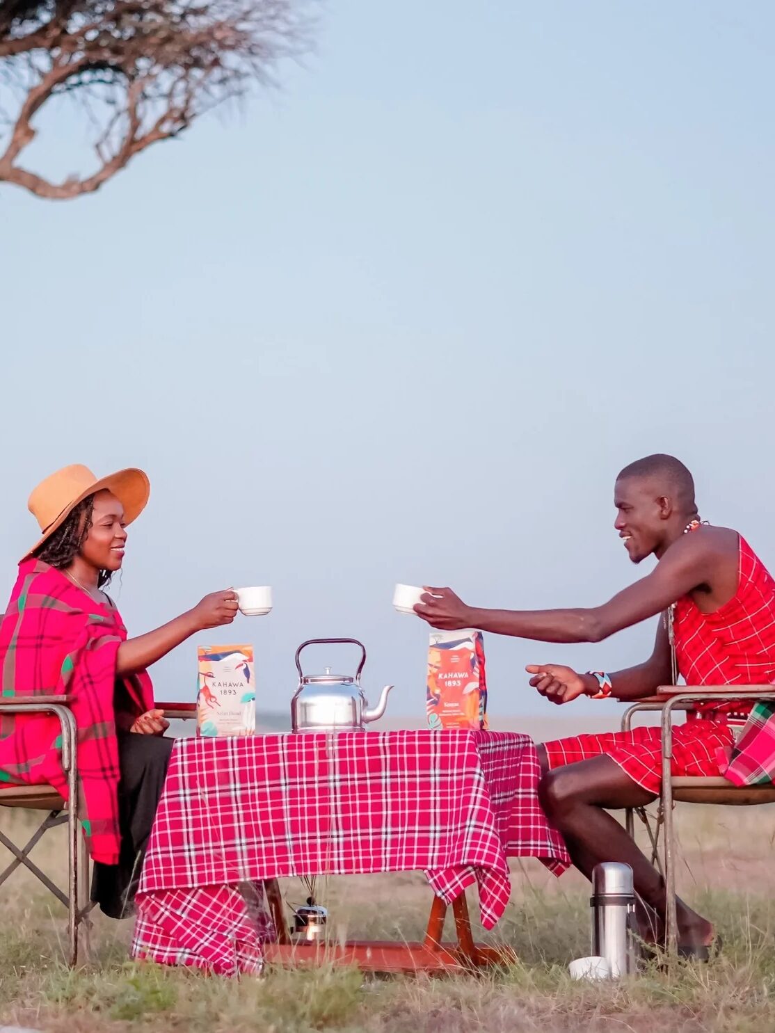 Two people cheers-ing their coffee mugs of Kahawa 1893 coffee.