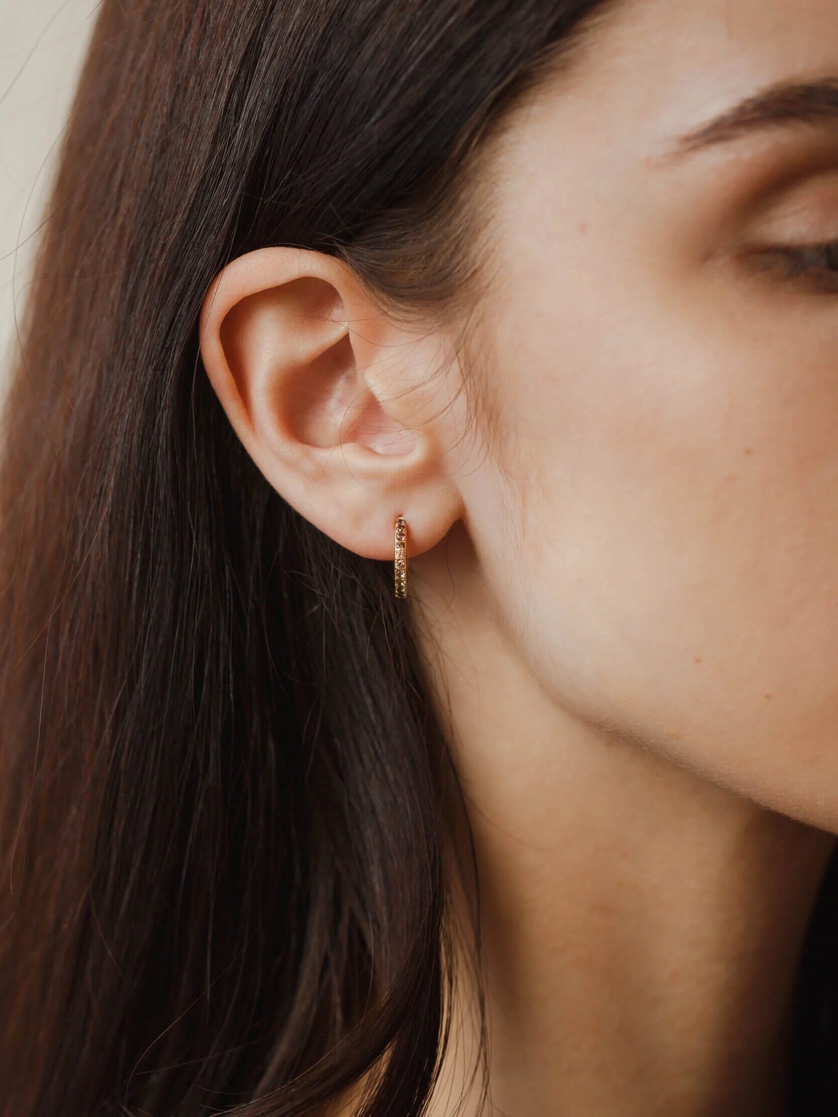 A model wearing GLDN Poet's Garden hoop earrings.