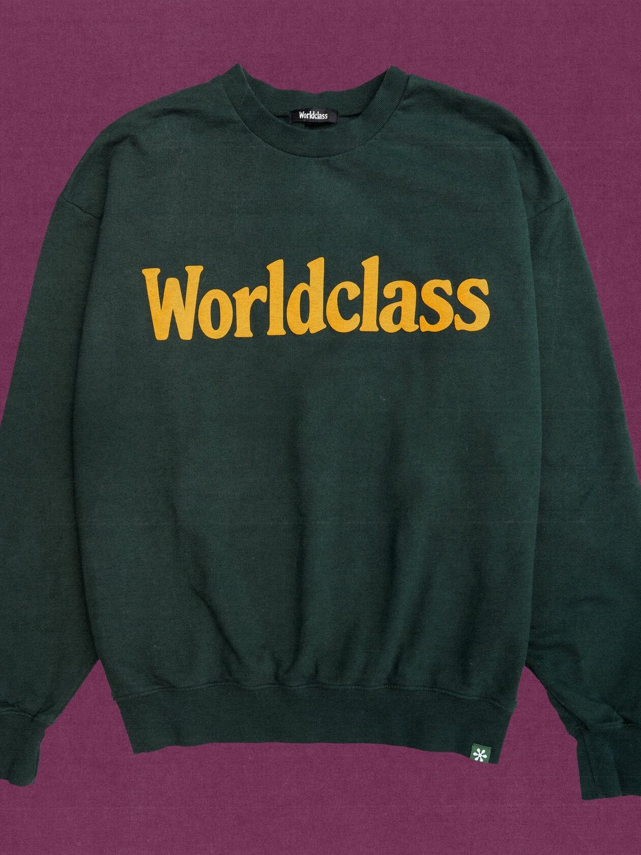 A green crewneck sweatshirt with the word "Worldclass" written across the chest in yellow.