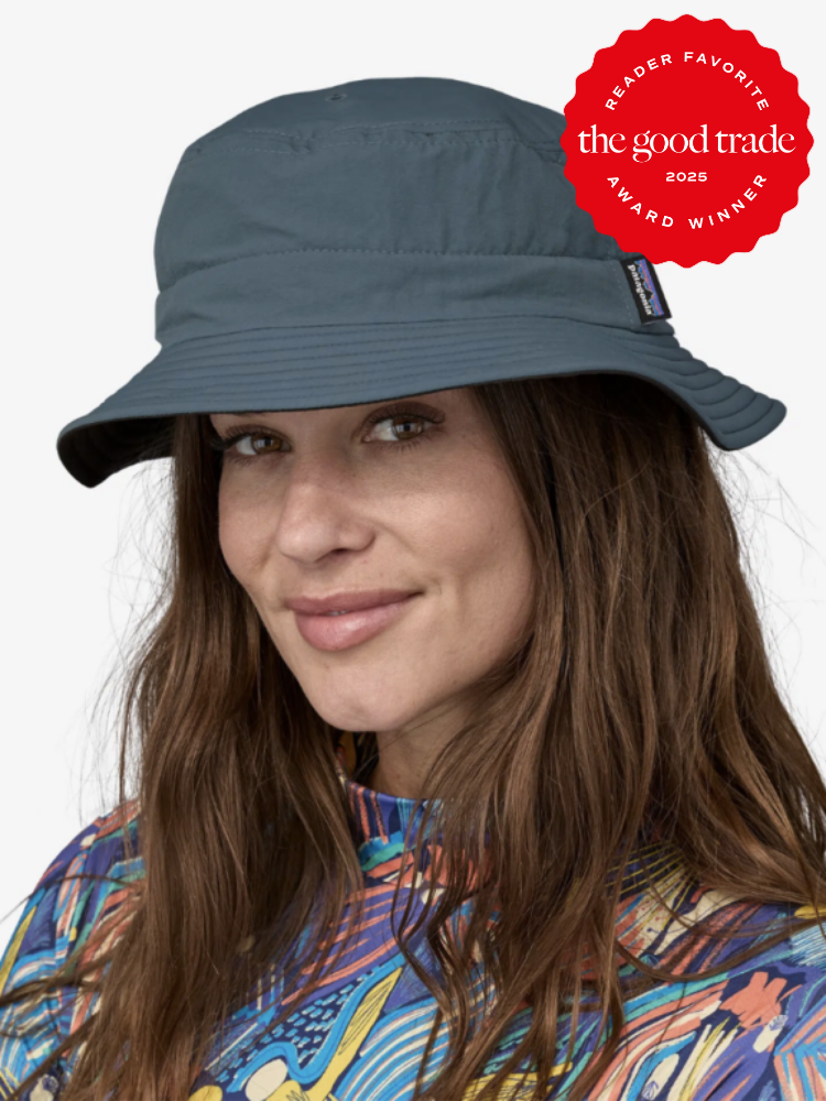 A person wearing a dark blue bucket hat and a colorful shirt, smiling. The image features a "Reader Favorite" award badge from The Good Trade.