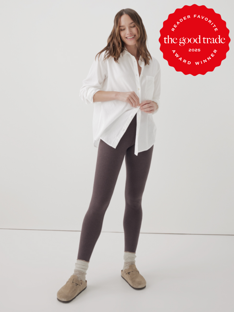 Person in a white shirt and dark leggings standing, smiling, with award badge reading "The Good Trade 2025 Reader Favorite.