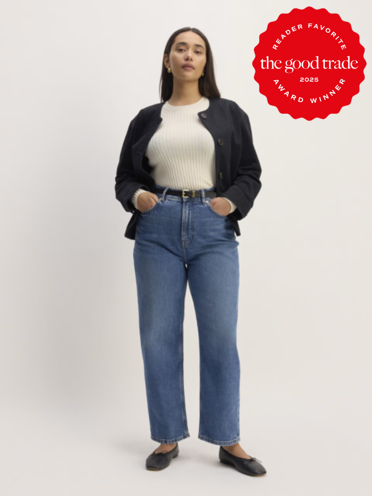 Person in casual attire stands confidently, wearing a black jacket, white sweater, blue jeans, and black shoes. A red "Reader Favorite The Good Trade 2025 Award Winner" badge is in the corner.