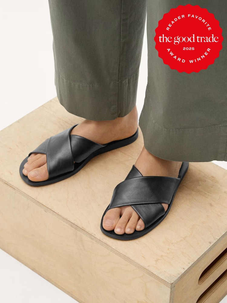 Person wearing black crisscross sandals stands on a wooden box. A red badge reads "Reader Favorite The Good Trade 2025 Award Winner.