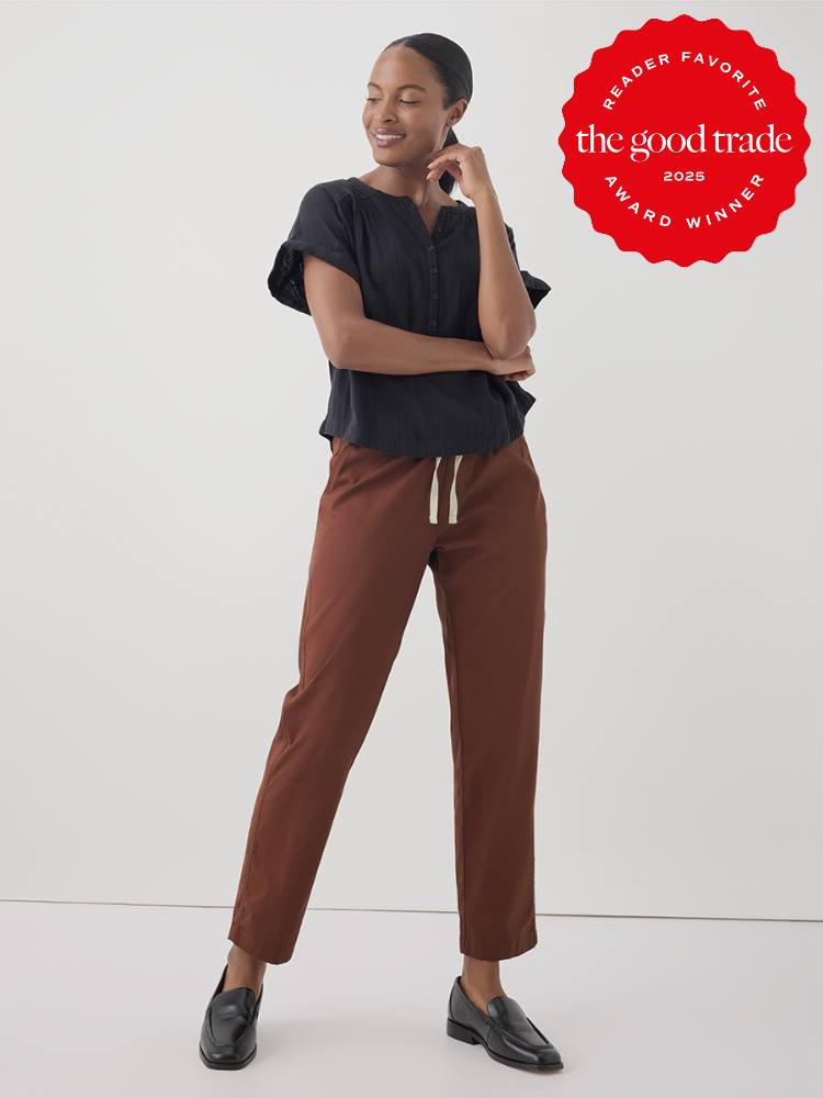 Person wearing a black blouse and brown pants, standing and smiling. The image includes a "Reader Favorite: The Good Trade 2025 Award Winner" badge.