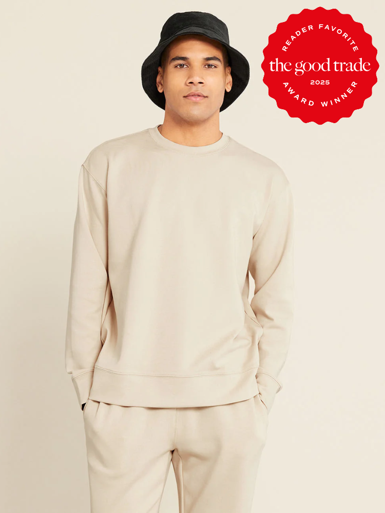 Person in a beige tracksuit and black bucket hat stands against a light background. A red badge reads, "The Good Trade 2025 Reader Favorite Award Winner.