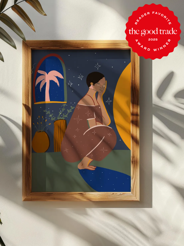 A framed illustration of a woman kneeling on a blue rug in a room with plants, stars, and a window; a red award badge appears in the top right corner.