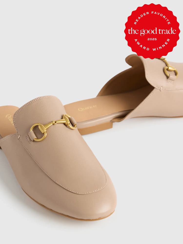 Beige slip-on mules with gold hardware featured against a white background. A red badge above reads "The Good Trade, Reader Favorite, Award Winner, 2023.