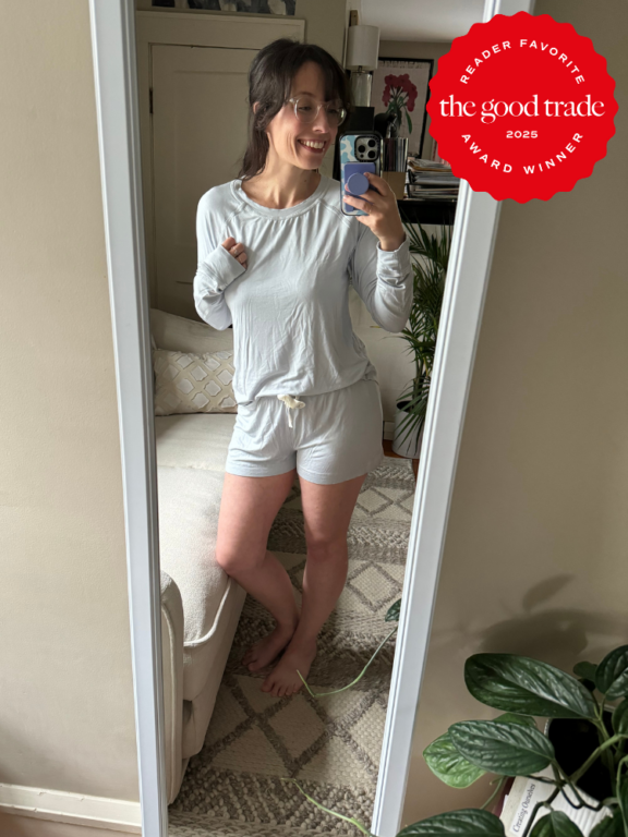 Woman taking a mirror selfie in a living room while wearing light-colored loungewear; a red "The Good Trade 2025 Award Winner" badge is overlaid in the top right corner.
