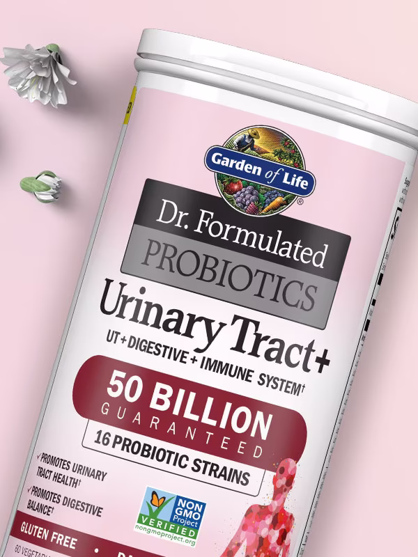 A container of Garden of Life Dr. Formulated Probiotics Urinary Tract+ is shown with cherry blossoms and the product name on a light background.